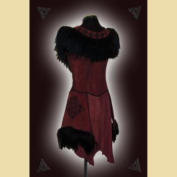 Dress made of burgundy suede. Decorated with lavish sheepskin trim, black trimmings, and black ornaments at the neckline and side panels. The skirt section shows the natural edges of the goat suede.