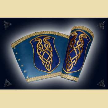 Armstulpen aus blauem Fettleder. Sie sind mit einer goldenen Schlangenstickereiund goldener Borte verziert. Sie werden mit Lederbändern geschnürt.