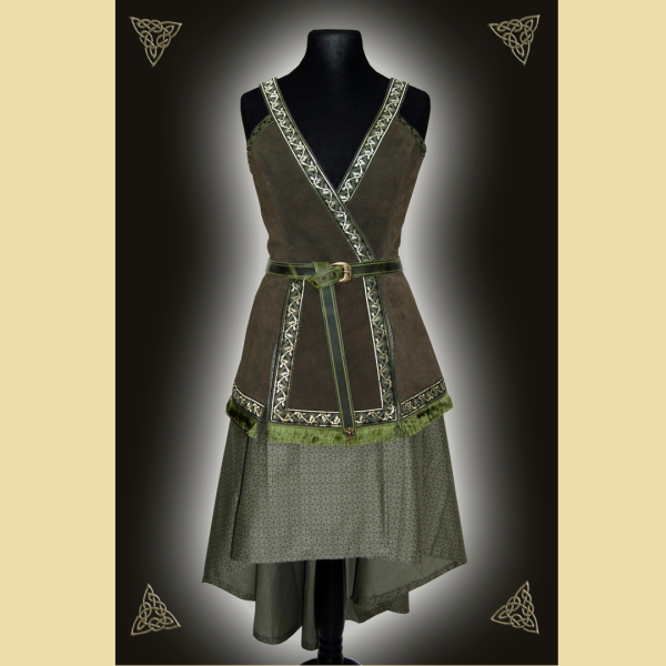 Kleid aus olivgrünem Rindveloursleder und einem zart gemusterten Baumwollstoff. Das Kleid ist verziert mit einem geknotet getragenem Gürtel, dekorativen Webborten und Fransenbesatz.