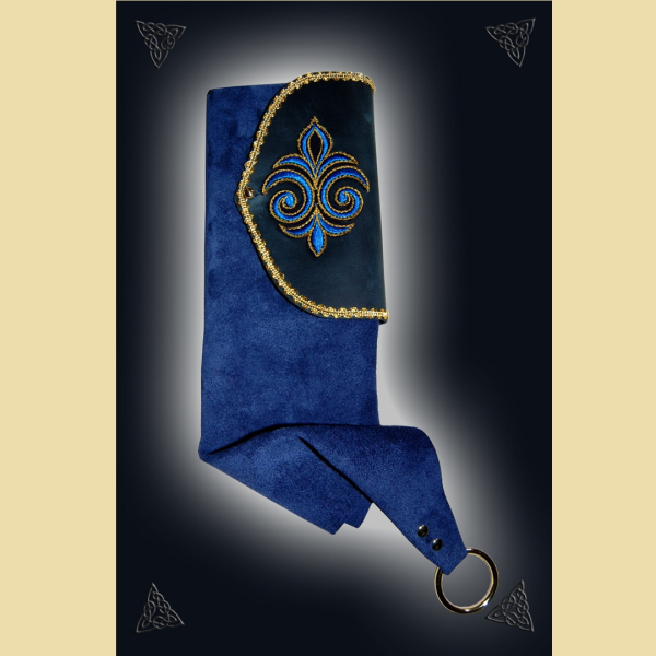 Beutelbuch aus blauem Rindveloursleder und Fettleder. Es ist verziert mit Goldbortenbesatz und einer gold-blauen, gestickten Fleur-de-Lis.  Das Buch besitzt DinA6-Format und hat ca. 100 weiße, unbeschriebene Seiten. Es kann mit einem starken Metallring am